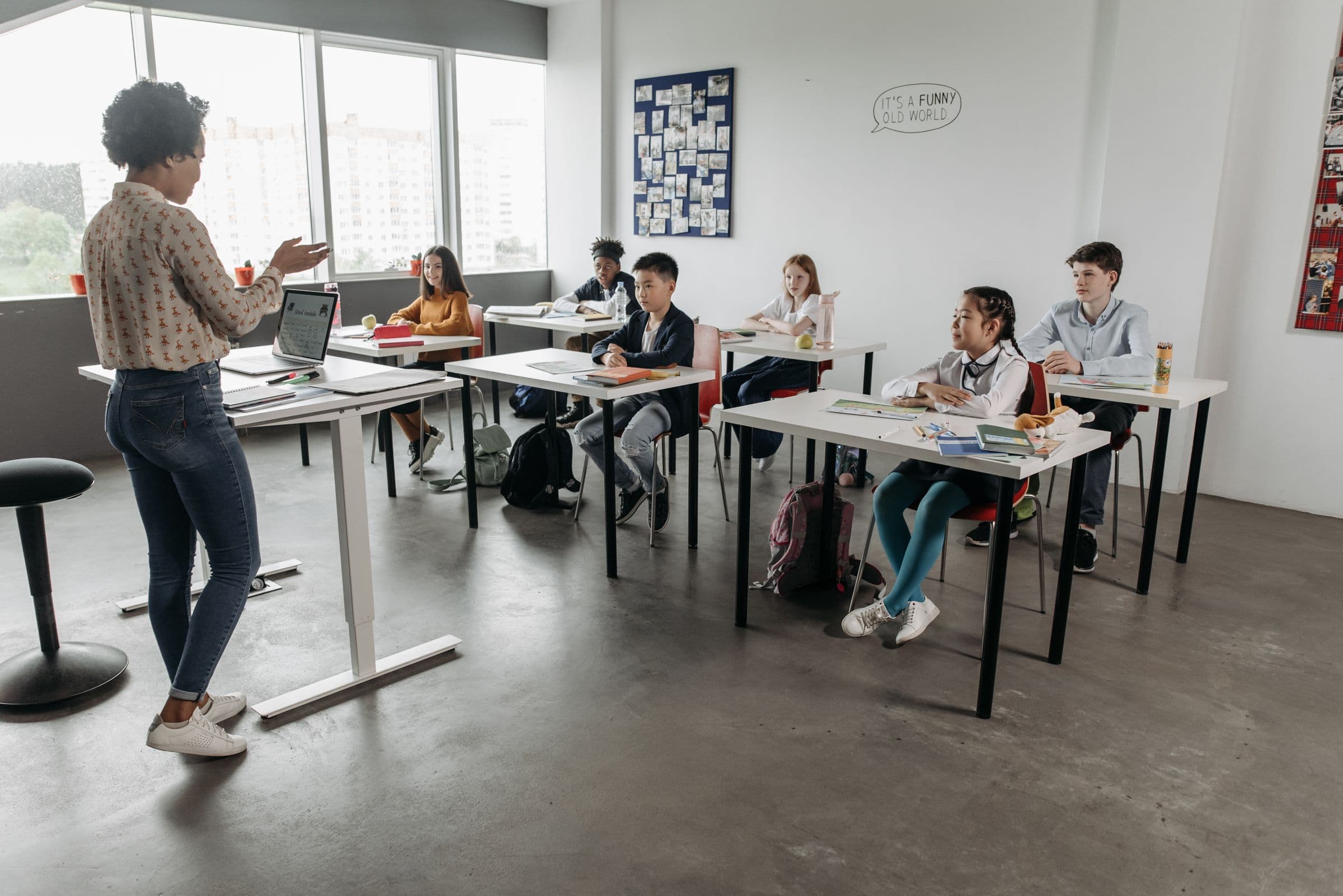 A teacher leading an engaged lesson in a bright, modern classroom of diverse students
